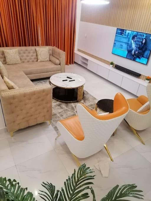 a living room with a couch and chairs and a table at Beautiful 2 bedroom in Ologolo in Lekki