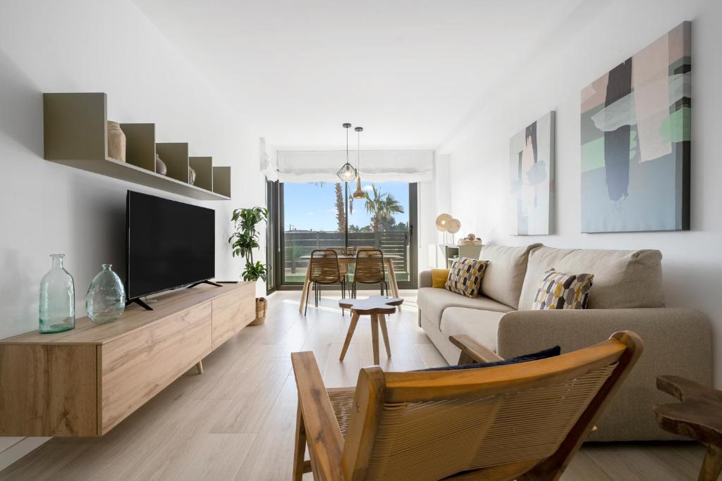 uma sala de estar com um sofá e uma televisão em Garbí by enjoy Rocas Doradas em L'Ametlla de Mar