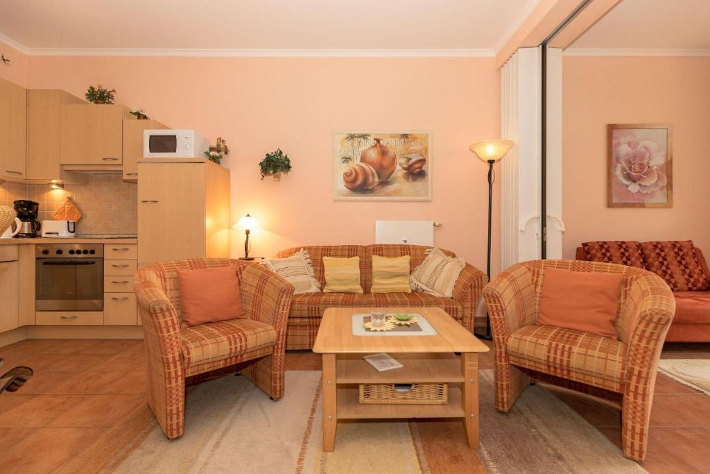 キュールングスボルンにあるDuenenschloss-Haus-1-Wohnung-12-487のリビングルーム(ソファ、椅子、テーブル付)