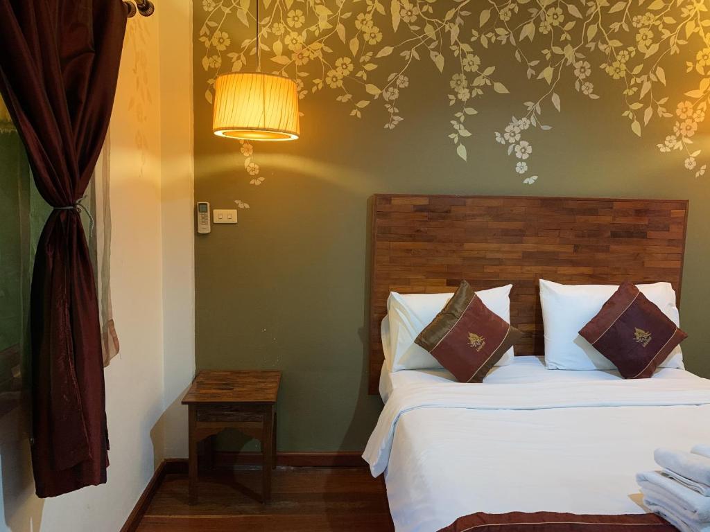 a bedroom with a bed and a lamp at Thapae Boutique House in Chiang Mai