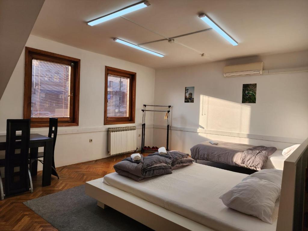 a bedroom with two beds and a table with a chair at Hostel Center in Sarajevo