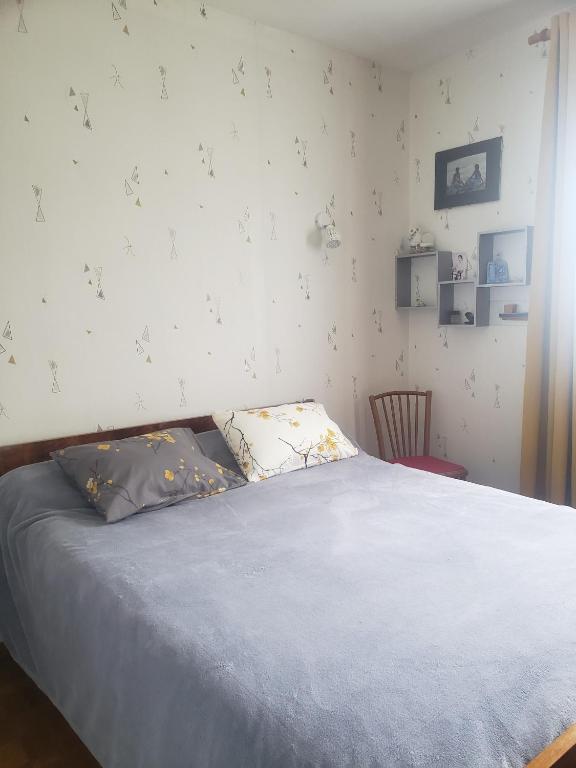 um quarto com uma cama com duas almofadas em Chambre chaleureuse à la campagne em Marennes