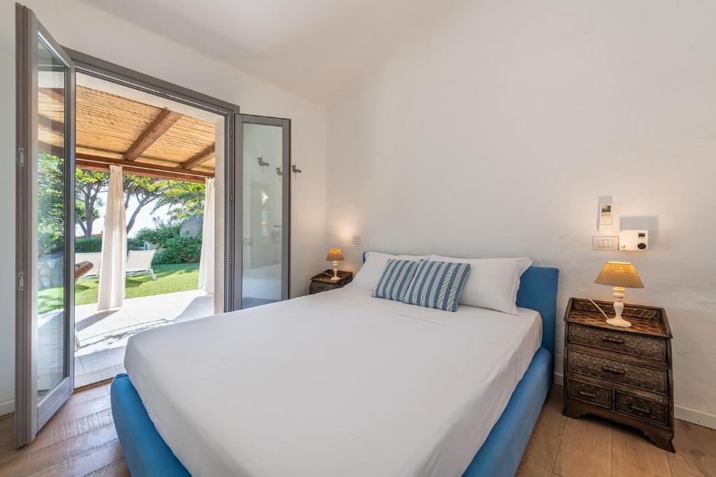 1 dormitorio con cama y ventana grande en DOMUS MARIS Villa Charmant Porto Giunco Notteri VILLASIMIUS en Notteri