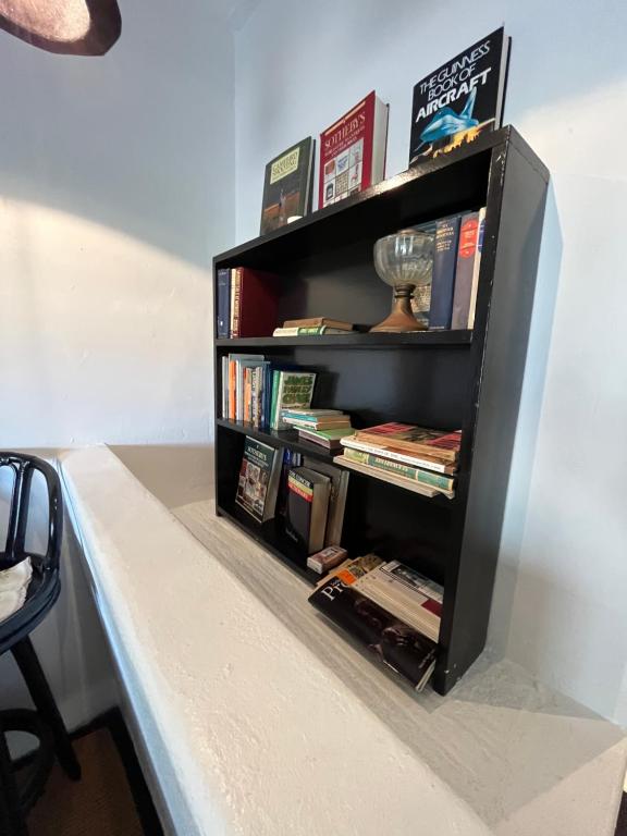 a black book shelf with books on it at The Stables in Protem