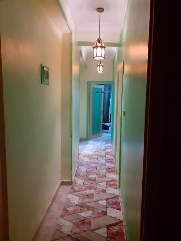 a hallway with green walls and a tile floor at Pyramid in Cairo