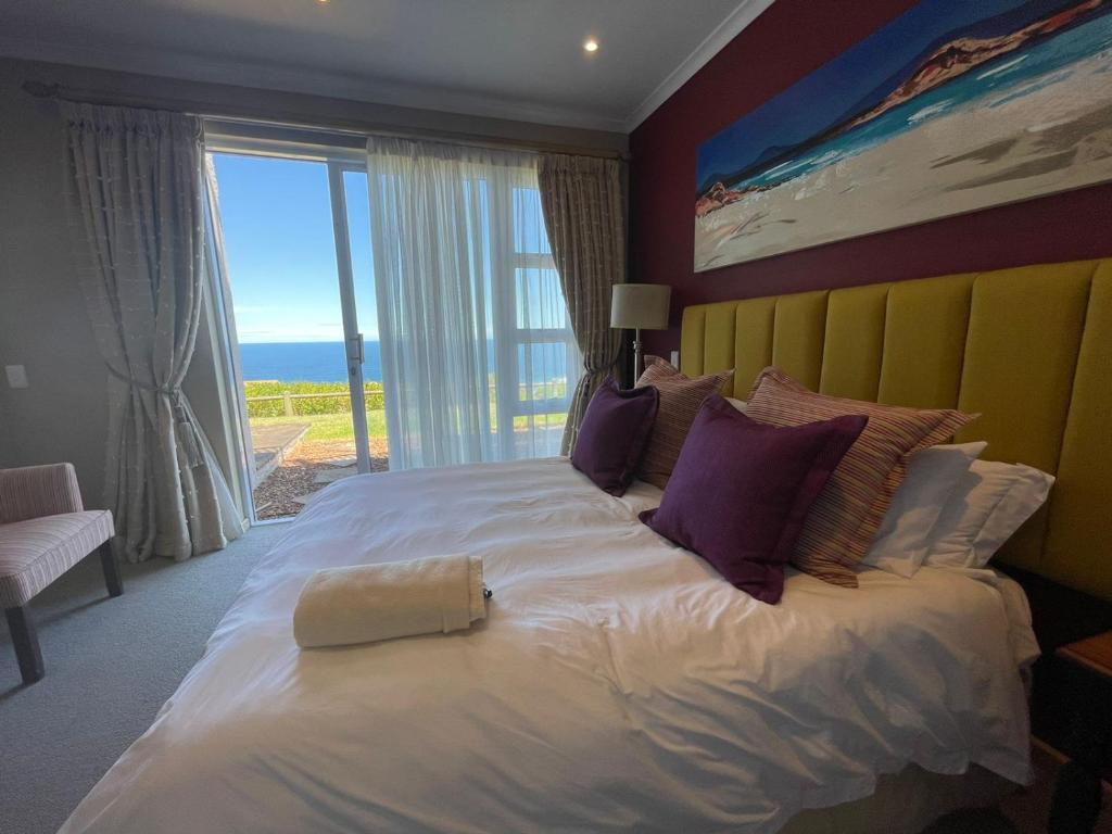 a large bed in a room with a large window at VIlla for Family and Golf in Mossel Bay
