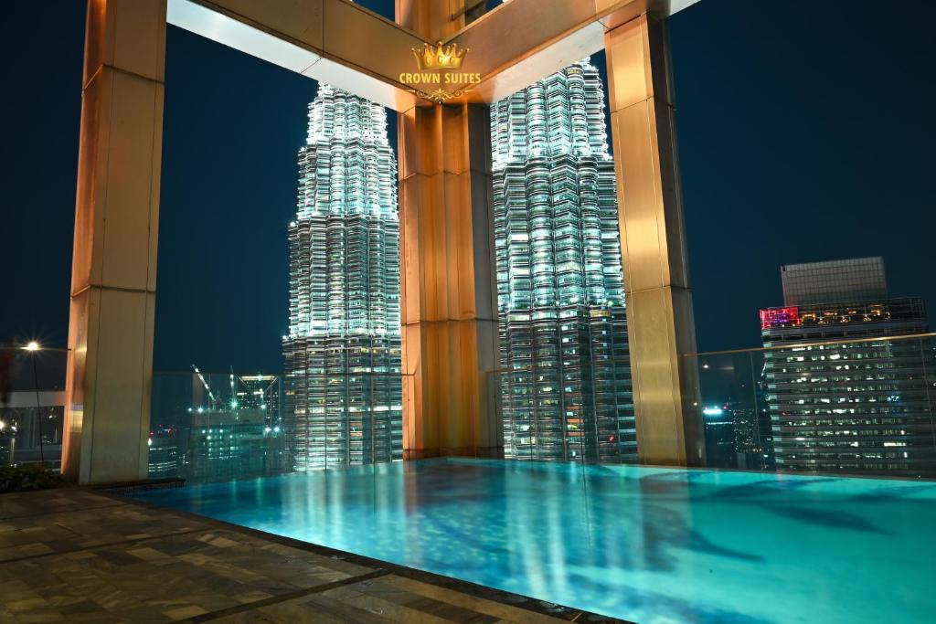 a swimming pool at night with a view of a city at Crown Suites Tropicana The Residence KLCC Bukit Bintang Kuala Lumpur in Kuala Lumpur