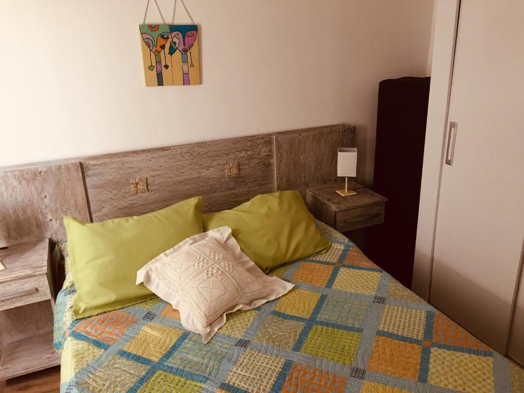 1 dormitorio con 1 cama con almohadas amarillas en Alquimia, en Sauce de Portezuelo