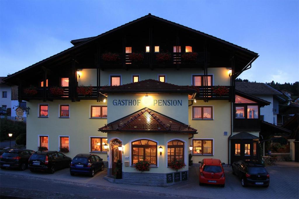 un gran edificio con coches estacionados frente a él en Gasthof Arracher Hof, en Arrach