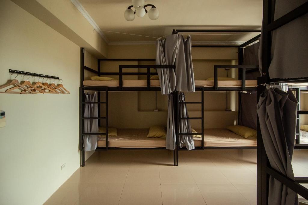 a room with three bunk beds in a room at Bare Foot Diving Hostel 2 in Hengchun