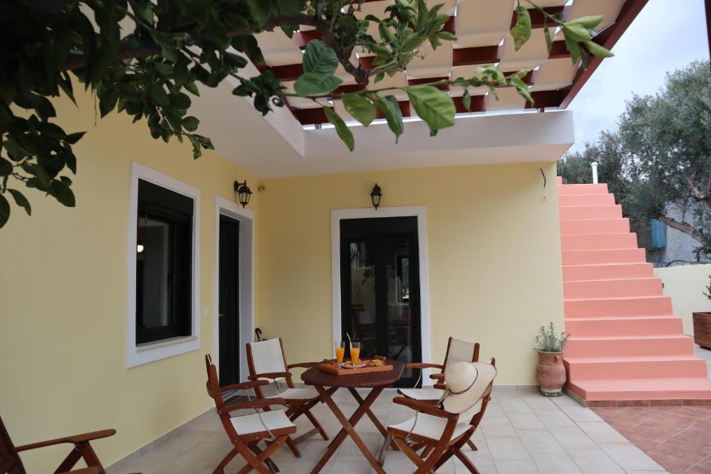 een patio met een tafel, stoelen en een trap bij Elpida's house in Ierápetra