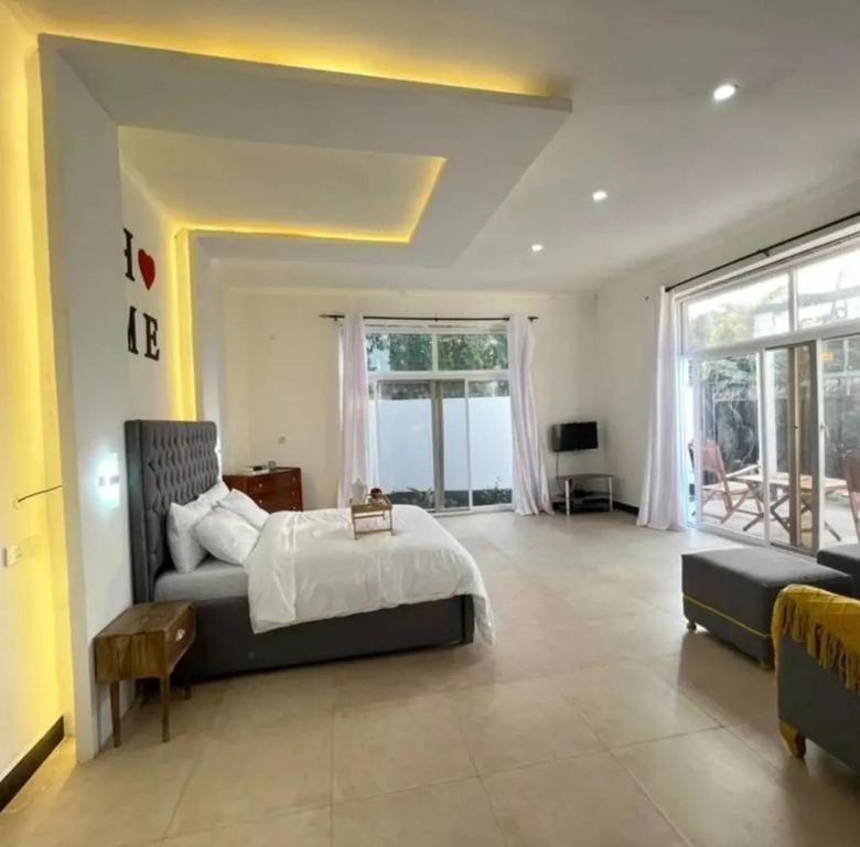 a large bedroom with a bed and a living room at Inviting 1-Bed Studio in Dar es Salaam in Dar es Salaam