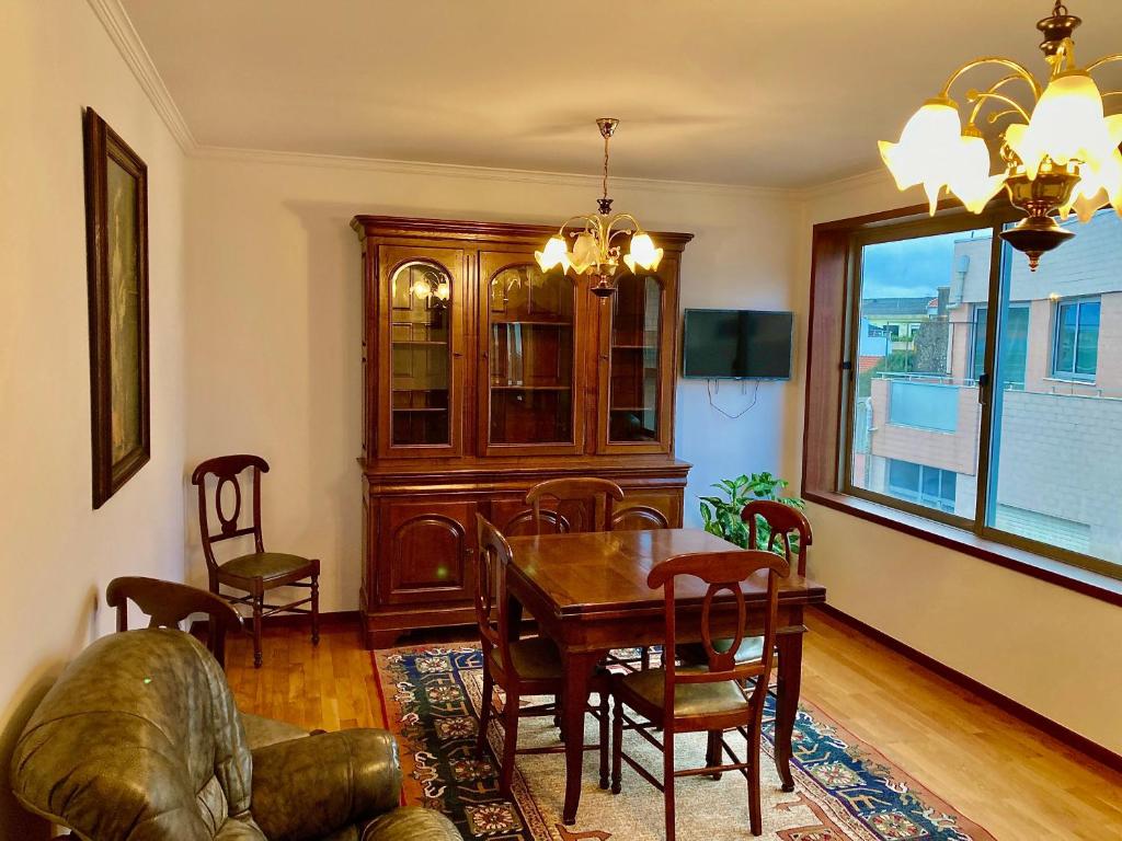 comedor con mesa, sillas y ventana en Povoa Center Beach Apartment, en Póvoa de Varzim