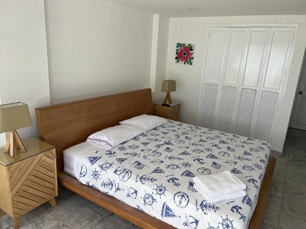 a bedroom with a bed with a blue and white comforter at Hermosos Apartamentos Frente Al Mar in San Andrés