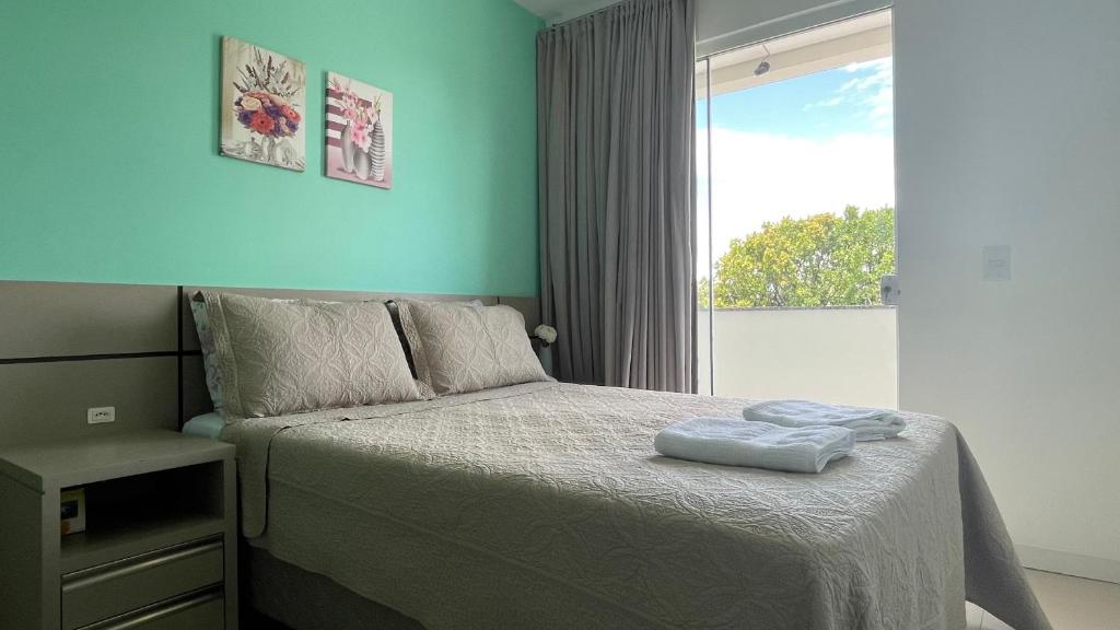 um pequeno quarto com uma cama e uma janela em Apartamento Praia de Navegantes Beto Carrero Balneário Camboriú em Navegantes