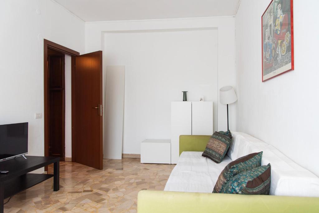 salon z białą kanapą i telewizorem w obiekcie YouHosty - Capecelatro 81 w Mediolanie