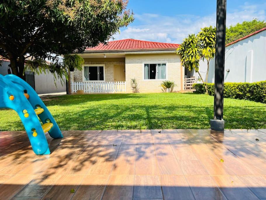 a blue slide in the yard of a house at Casa Bignonia Amplio y confortable Ideal para familias con niños y mascotas in Ciudad del Este