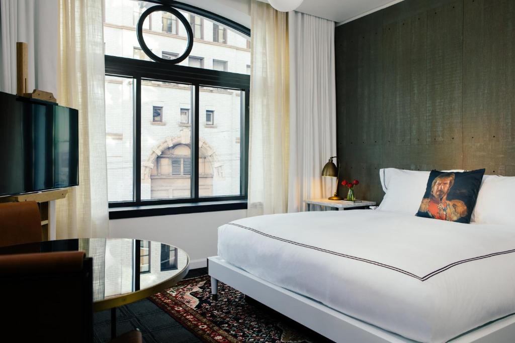 a bedroom with a large white bed and a window at Kimpton Palladian Hotel, an IHG Hotel in Seattle