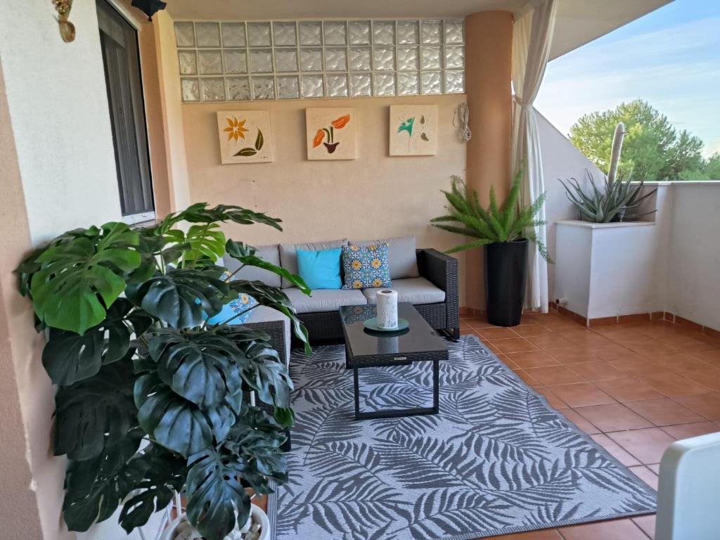 eine Terrasse mit einem Sofa und Pflanzen auf einem Balkon in der Unterkunft Hacienda Dona JULIA GOLF Estepona in Casares