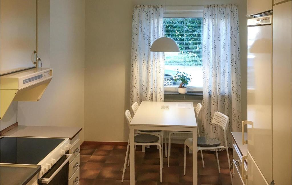 une cuisine avec une table et des chaises ainsi qu'une fenêtre dans l'établissement Stunning Apartment In Kvillsfors With Kitchen, à Kvillsfors