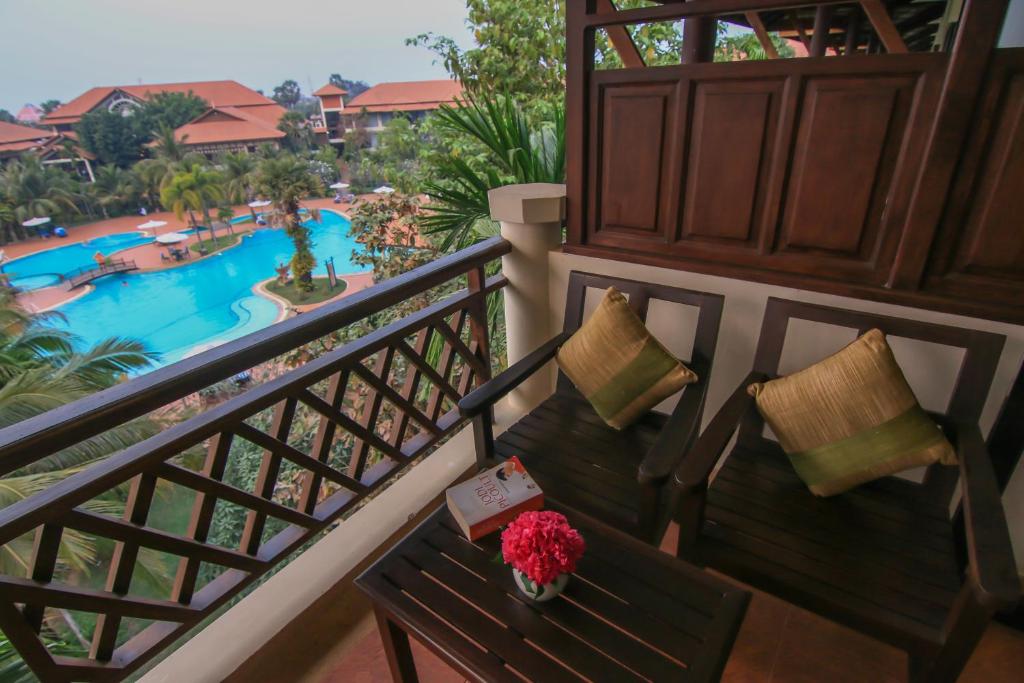 a balcony with a bench with a view of a pool at Palace Residence & Villa Siem Reap in Siem Reap