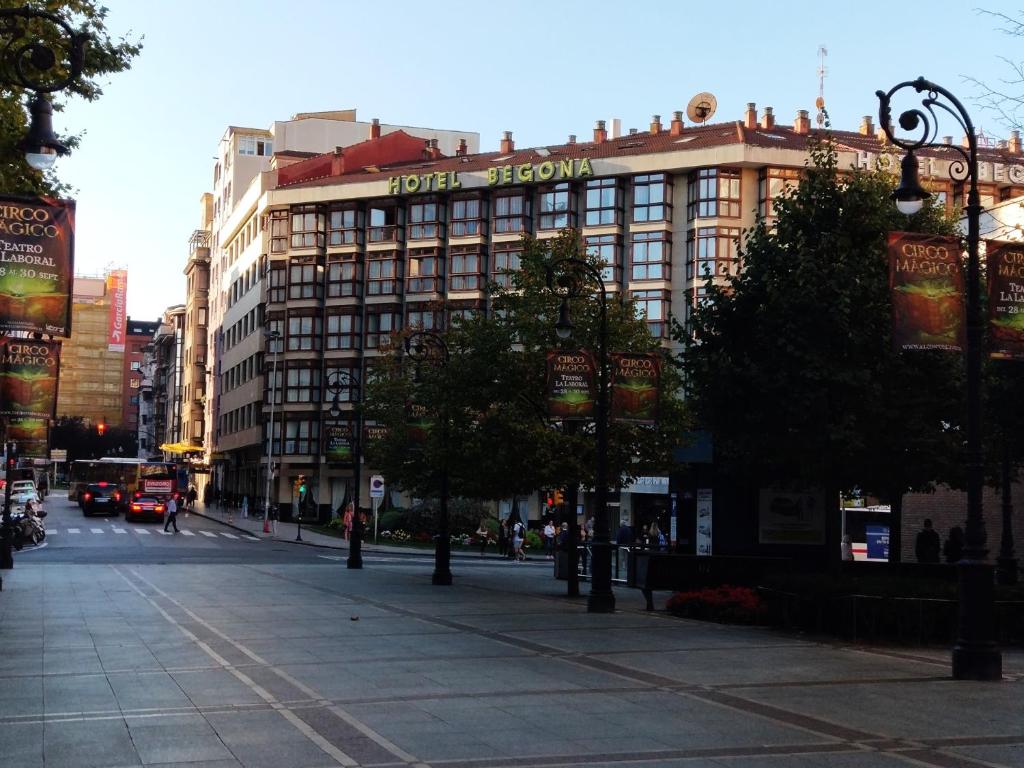 un grand bâtiment avec un panneau sur une rue de la ville dans l'établissement Hotel Begoña, à Gijón