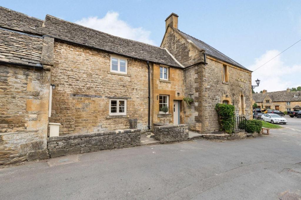 an old brick building with a car parked outside at The Cotswold Lady in Guiting Power