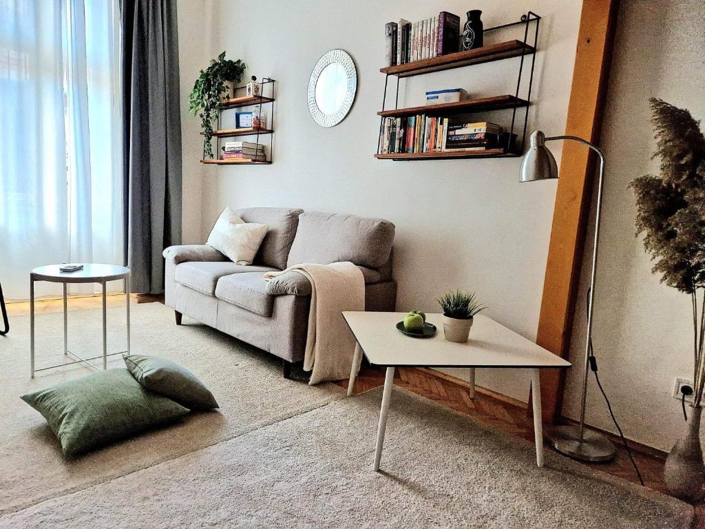 uma sala de estar com um sofá e uma mesa em Christie's Downtown Apartment em Budapeste
