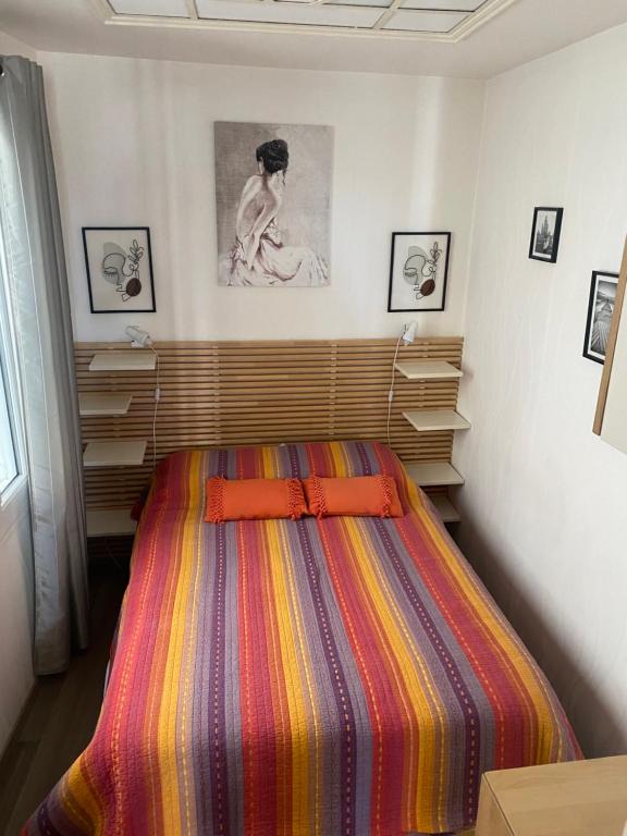 トゥルヴィル・シュル・メールにあるAU 112のベッドルーム1室(カラフルなストライプ毛布付きのベッド1台付)
