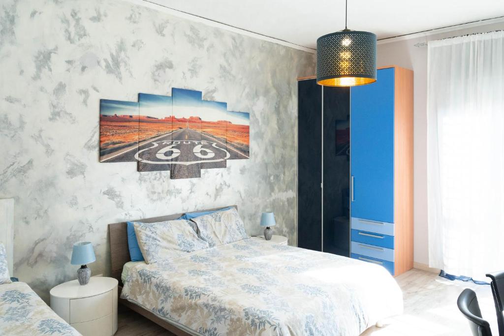 ナポリにあるBEDandFLYのベッドルーム1室(ベッド1台付)が備わります。壁には絵画が飾られています。