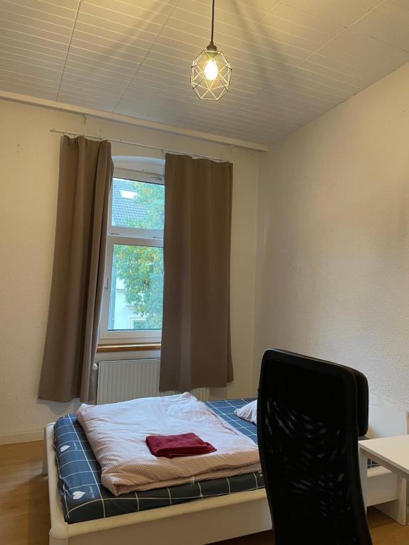a bedroom with a bed with a window and a chair at Lovely room in Düsseldorf nearly Düsseldorf Hbf in Düsseldorf