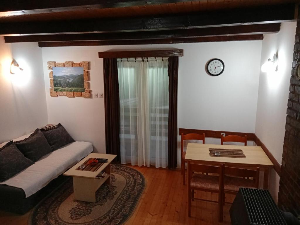 een woonkamer met een bank en een tafel bij Vila Ivana in Mitrovac