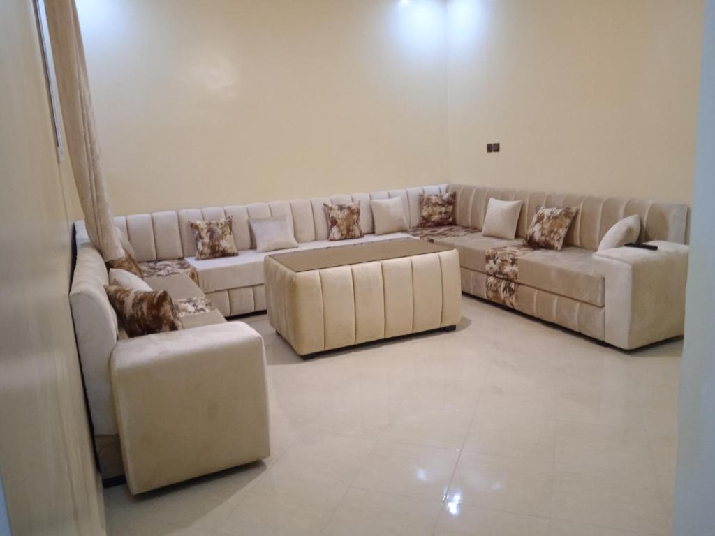 Sala de estar con 2 sofás y 2 ottos en Appartement à louer Tiznit 2, en Tiznit