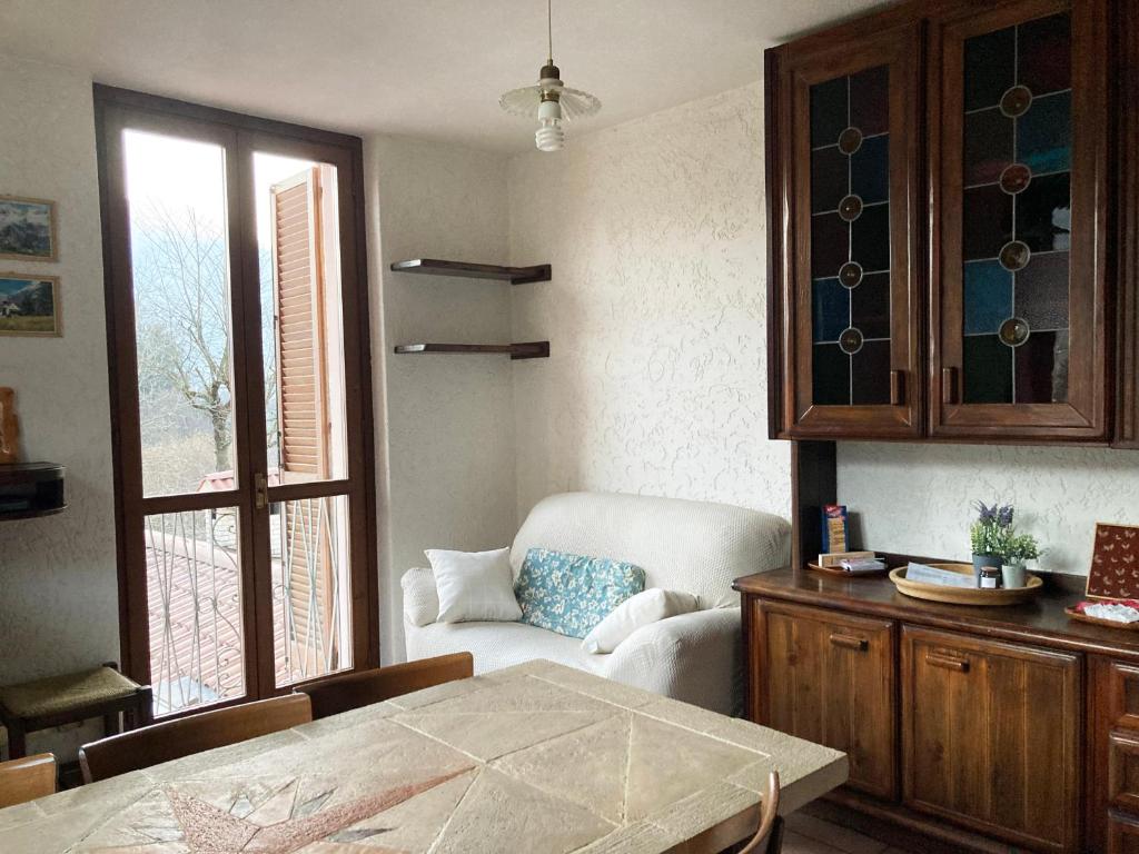バルツィオにあるMountain lodging with fireplace and mountain viewのリビングルーム(テーブル、椅子付)、窓が備わります。