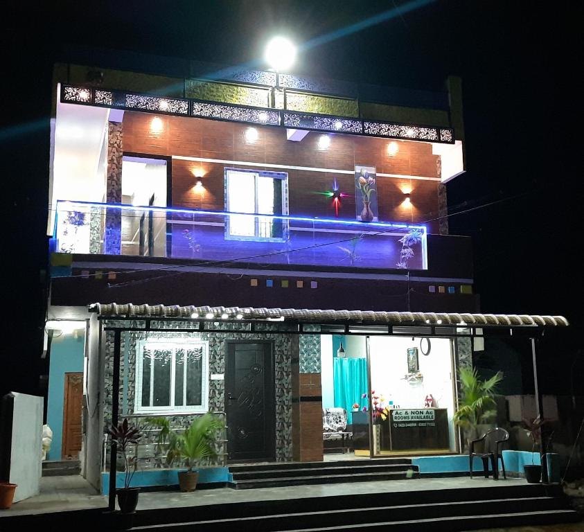 a house with a lit up facade at night at Teja Residency in Alāndurai