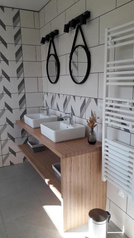 a bathroom with two sinks and two mirrors on the wall at GITE LES 3 EDELWEISS - Maison SEGUITTE - 6 PERSONNES in Arette