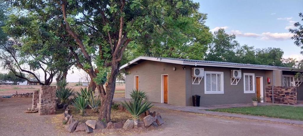 una pequeña casa con árboles delante de ella en Koha Guesthouse en Mariental