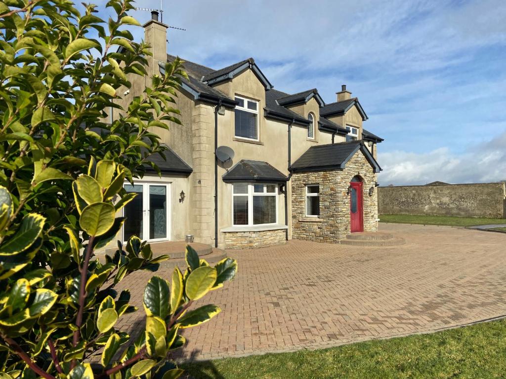 a house with a red door on a brick driveway at Sheriffs Mountain Lodge in Derry Londonderry