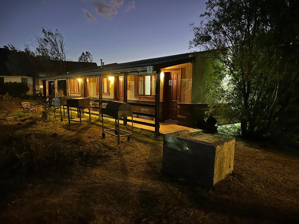 una casa con luces encendidas en un patio por la noche en Bungalow Rio Olivia en Ushuaia