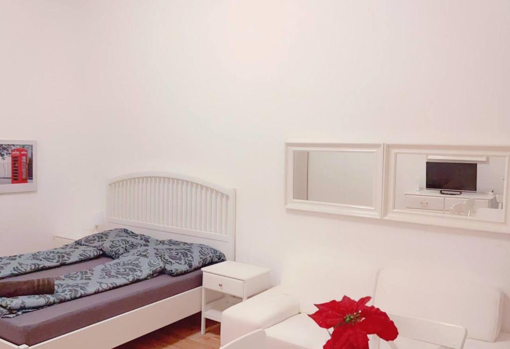a white bedroom with a bed and a tv at Premier Studio 2P LG in Vienna