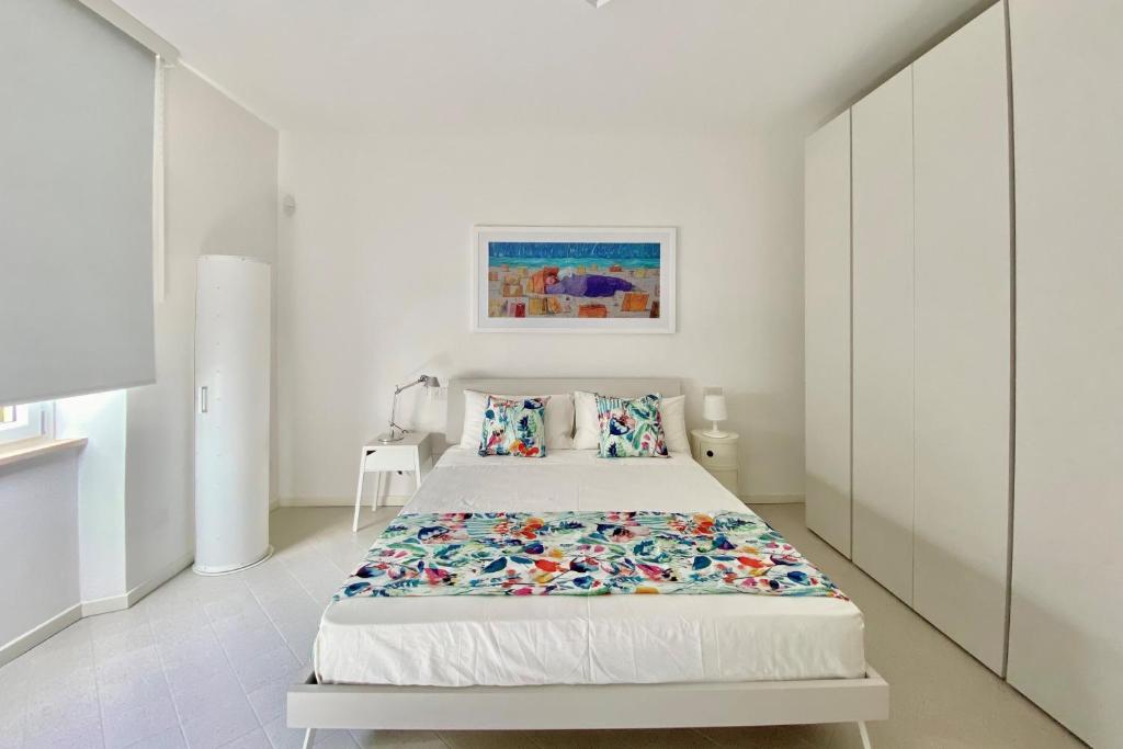 a white bedroom with a bed in a room at Via Zug in Castiglioncello