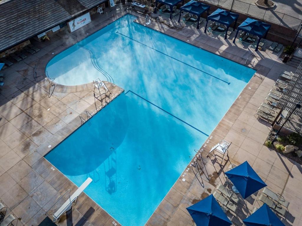 an overhead view of a large blue swimming pool with umbrellas at Villa 27 - 4 Bedroom Townhome! Pool and Hot Tub! in St. George
