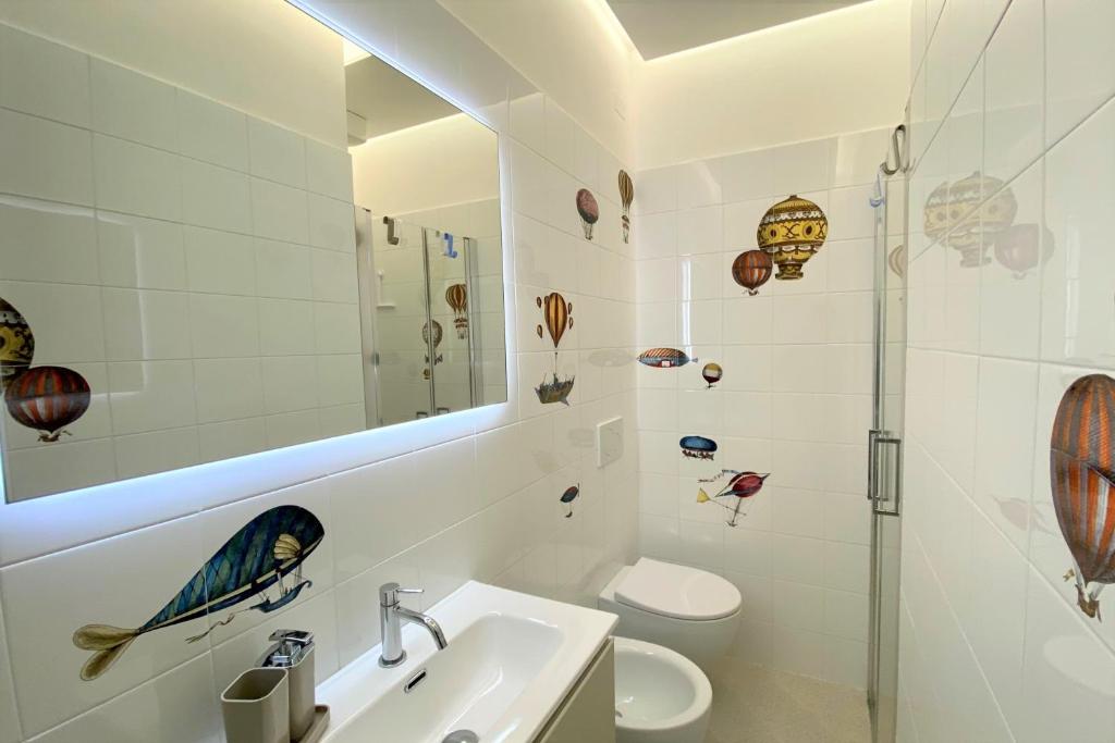 a bathroom with a sink and a toilet and a mirror at Via Zug in Castiglioncello