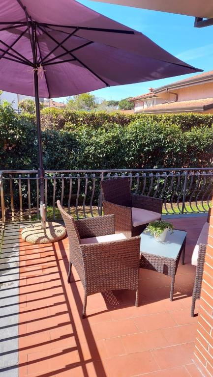 a patio with an umbrella and chairs and a table at Villa Daria in Forte dei Marmi
