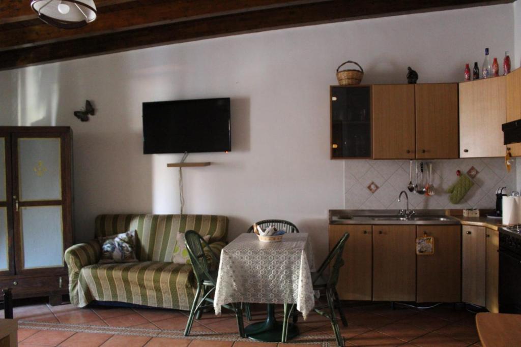cocina y sala de estar con mesa y sofá. en Mary home, en SantʼAlessio Siculo