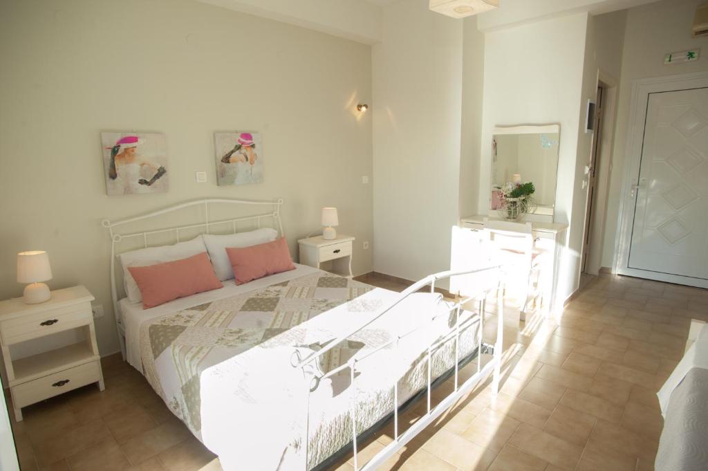 um quarto com uma cama branca e almofadas cor-de-rosa em Musses Studios em Minia