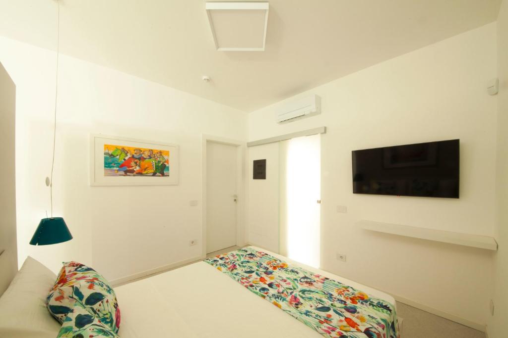 a white living room with a couch and a tv at Via Zug in Castiglioncello