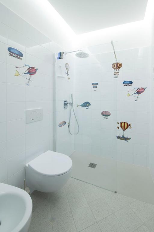 a bathroom with a toilet and a shower with fish stickers at Via Zug in Castiglioncello