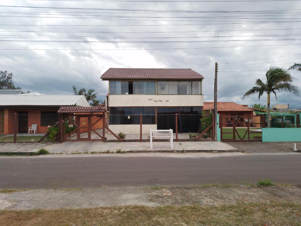 ein Gebäude mit einer Bank vor einer Straße in der Unterkunft Apt com vista para o mar in Capão da Canoa
