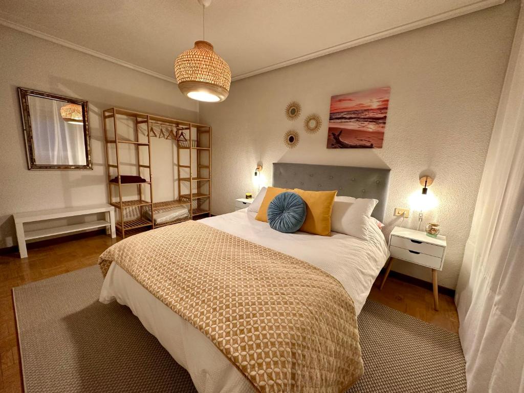 una camera da letto con un grande letto con cuscini gialli e blu di Villa Yoli, céntrico con plaza de garaje ad Avilés